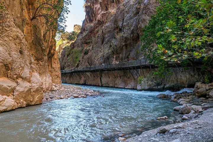 Wooden walkway suspended on a cliff edge above a rushing river in Saklikent Gorge